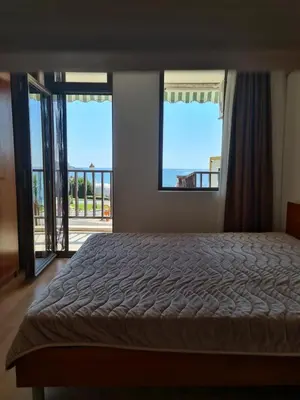 a bedroom with a bed and a view of the ocean at Апартамент с фронтална гледка море in Sveti Vlas