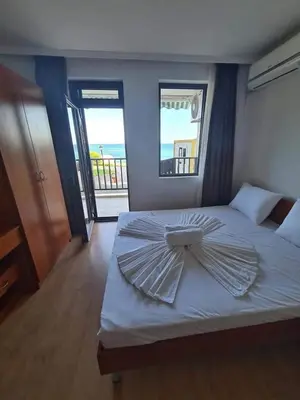 a bed with an umbrella on top of it at Апартамент с фронтална гледка море in Sveti Vlas