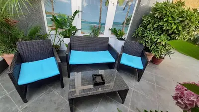 three chairs and a table on a porch with plants at Laguna in Kiten
