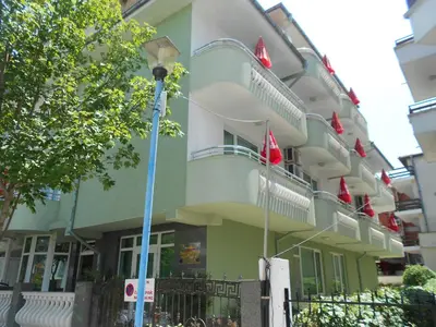 a building with red flags on the side of it at Laguna in Kiten