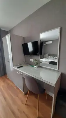 a desk with a mirror and a bed in a room at Laguna in Kiten