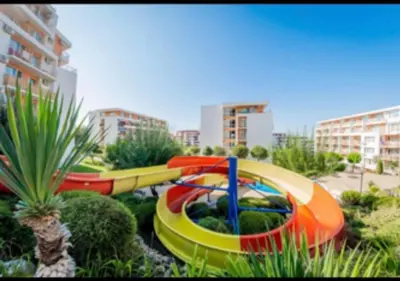a group of colorful water slides in a park at 2-комнатные апартаменты у моря 10 бассейнов Crown Fort Noks in Sveti Vlas