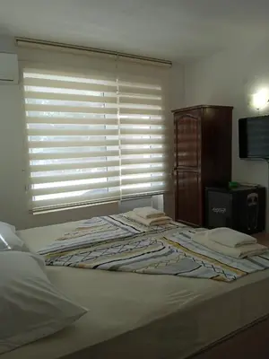a bedroom with a bed with a window with blinds at Guest House DARIS-APHRODEYA Къща за Гости ДАРИС-АФРОДЕЯ in Sozopol