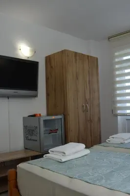 a bedroom with a tv and a bed with towels at Guest House DARIS-APHRODEYA Къща за Гости ДАРИС-АФРОДЕЯ in Sozopol
