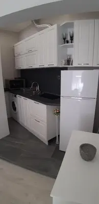 a kitchen with white cabinets and a white refrigerator at Sea & chill suite in Burgas City