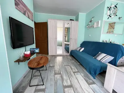 a living room with a blue couch and a tv at Bright 1BD Apartment with Nice Terrace by Flat Mаnаger in Burgas City