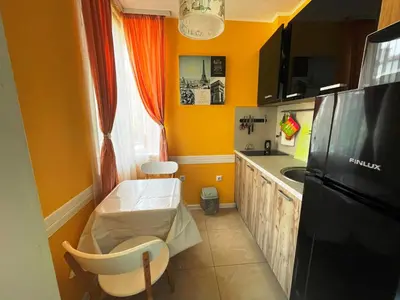 a kitchen with yellow walls and a black refrigerator at Bright 1BD Apartment with Nice Terrace by Flat Mаnаger in Burgas City