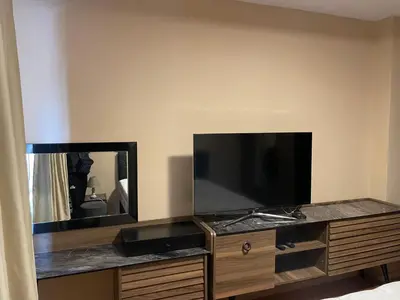 a flat screen tv on a wooden dresser with a mirror at Apartment The Room in Burgas City