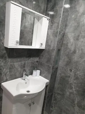 a bathroom with a white sink and a mirror at Apartment The Room in Burgas City