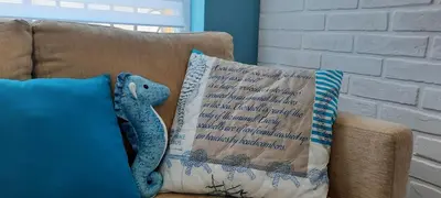 a blue pillow with a teddy bear on a couch at Нава 8 in Burgas City