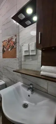 a bathroom with a white sink and a mirror at Нава 8 in Burgas City
