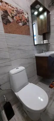 a bathroom with a white toilet and a sink at Нава 8 in Burgas City