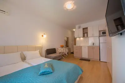 a living room with a white couch and a kitchen at Sunny View Central Holiday Apartments in Sunny Beach