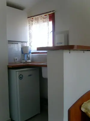 a small kitchen with a counter and a window at Сотирови, самостоятелни стаи in Chernomorets