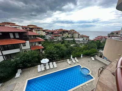 a swimming pool with lounge chairs and a view of the ocean at Sirena in Sveti Vlas