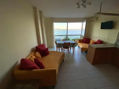 a living room with two couches and a table and chairs at Amrita apartments Nessebar in Nesebar