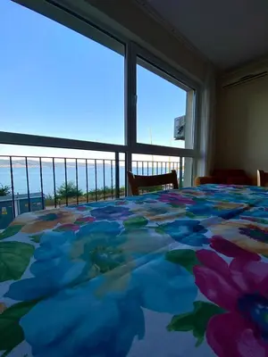 a bedroom with a bed with a view of the ocean at Amrita apartments Nessebar in Nesebar