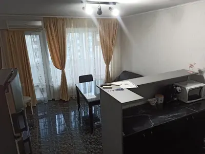 a room with a desk with a microwave and a table at Апартамент Арена Бургас in Burgas City