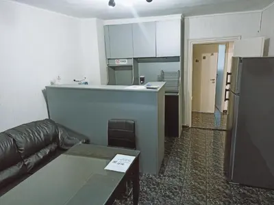 a living room with a couch and a kitchen at Апартамент Арена Бургас in Burgas City