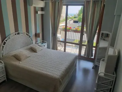 a bedroom with a bed and a view of a balcony at Lilly apartment Pomorie in Pomorie