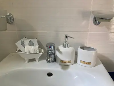 a bathroom sink with a faucet and toiletries on it at Hacienda Beach complex- Nicoleta apartment in Sozopol