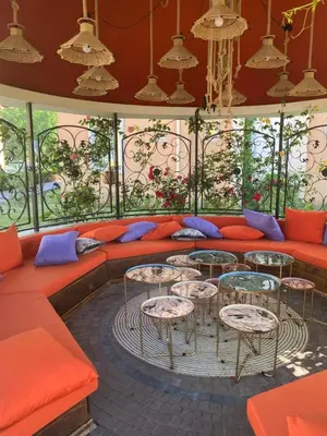 a room with a couch and tables and windows at Hacienda Beach complex- Nicoleta apartment in Sozopol