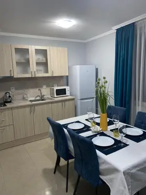 a kitchen with a table with blue chairs and a kitchen with a tableablish at Hacienda Beach complex- Nicoleta apartment in Sozopol