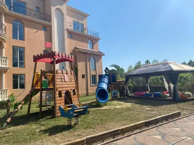 a playground in a yard next to a building at Hacienda Beach complex- Nicoleta apartment in Sozopol