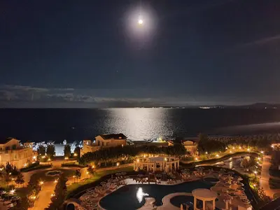 a view of a resort at night with a full moon at Апартамент Сънсет Ризорт in Pomorie