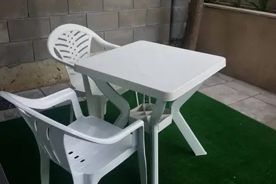 a white table and two white chairs on the grass at Studio in the center of Sarafovo in Burgas City