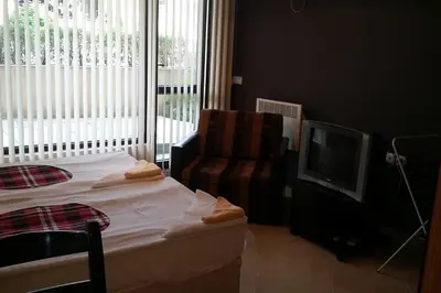 a living room with a chair and a television at Studio in the center of Sarafovo in Burgas City