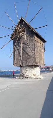 a large wooden windmill sitting on top of a beach at Глобал вил in Sunny Beach