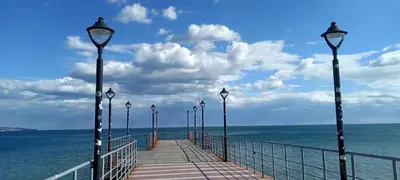 a pier with street lights on the water at Глобал вил in Sunny Beach