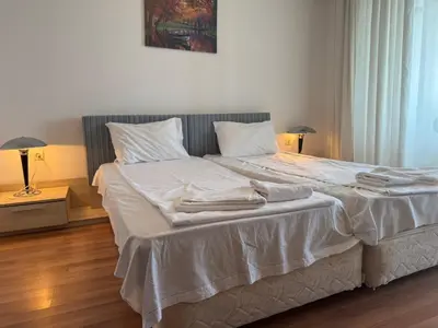 a bedroom with a bed with white sheets and pillows at Fenix Apart Complex in Sveti Vlas