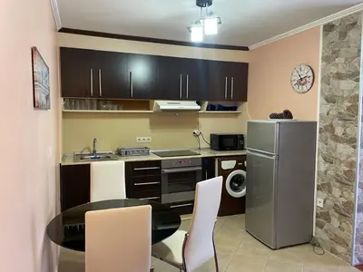a small kitchen with a table and a refrigerator at VIP Style private apartments in Elenite