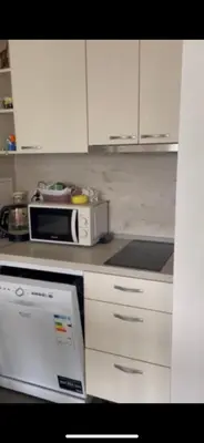 a kitchen with white cabinets and a microwave at Bryan