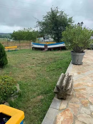 a bench and a boat in a yard at Апартамент Нели in Ravadinovo