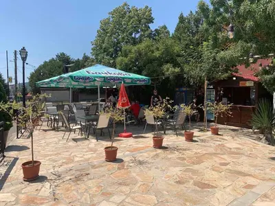 a patio with a table and chairs and an umbrella at Апартамент Нели in Ravadinovo