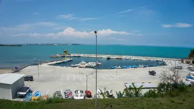 a marina with cars parked in a parking lot at Kraimorie Park in Burgas City