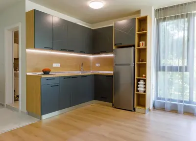 a kitchen with blue cabinets and a refrigerator at Kraimorie Park in Burgas City