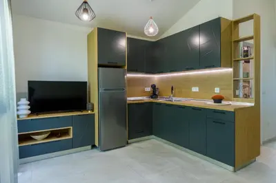 a kitchen with dark blue cabinets and a tv at Kraimorie Park in Burgas City