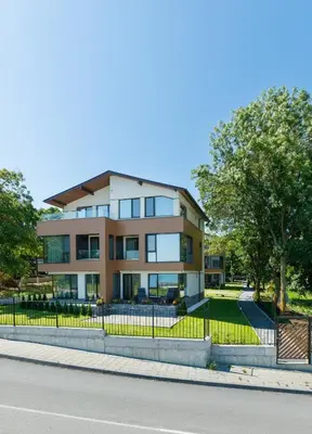 a building with a fence in front of a street at Kraimorie Park in Burgas City