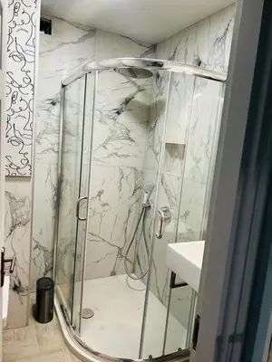 a bathroom with a shower with a glass door at ADIRAMAR Apartments in Obzor