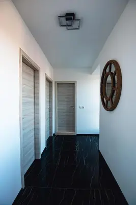 a hallway with a black tile floor and a mirror at Modern Spacious 1BD Apartment for two in Nesebar by Flat Mаnаger in Nesebar