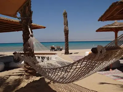a hammock on a beach with the ocean at Апартамент Лагуна Aйланд in Sozopol