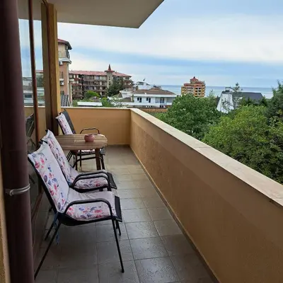 a balcony with two chairs and a table at Perla 1 apartments in Ravda