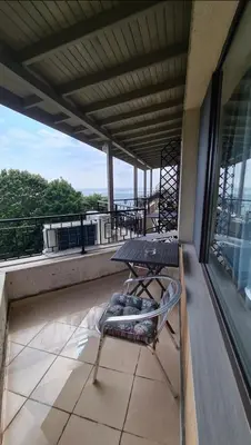 a balcony with a table and a chair on a roof at Apartment on the beach 2 in Ravda