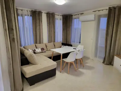 a living room with a couch and a table and chairs at Apartment on the beach 2 in Ravda