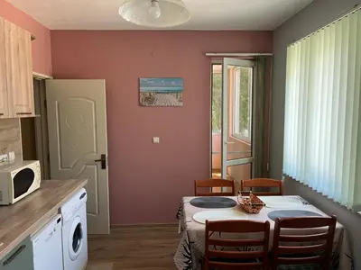 a kitchen with a table with chairs and a microwave at Apartment Mihaela in Burgas City