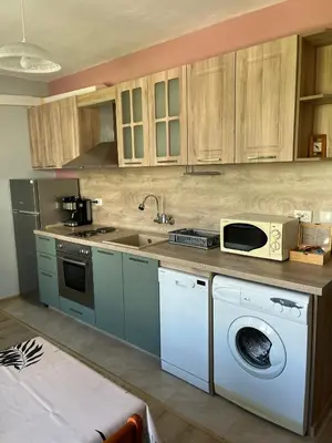 a kitchen with a washing machine and a microwave at Apartment Mihaela in Burgas City